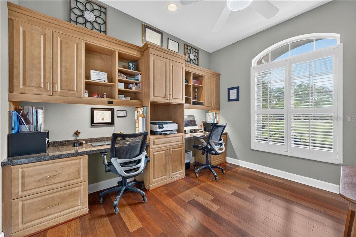 Near the front entry, the dedicated office features plantation shutters, built-in cabinetry and ample workspaces.