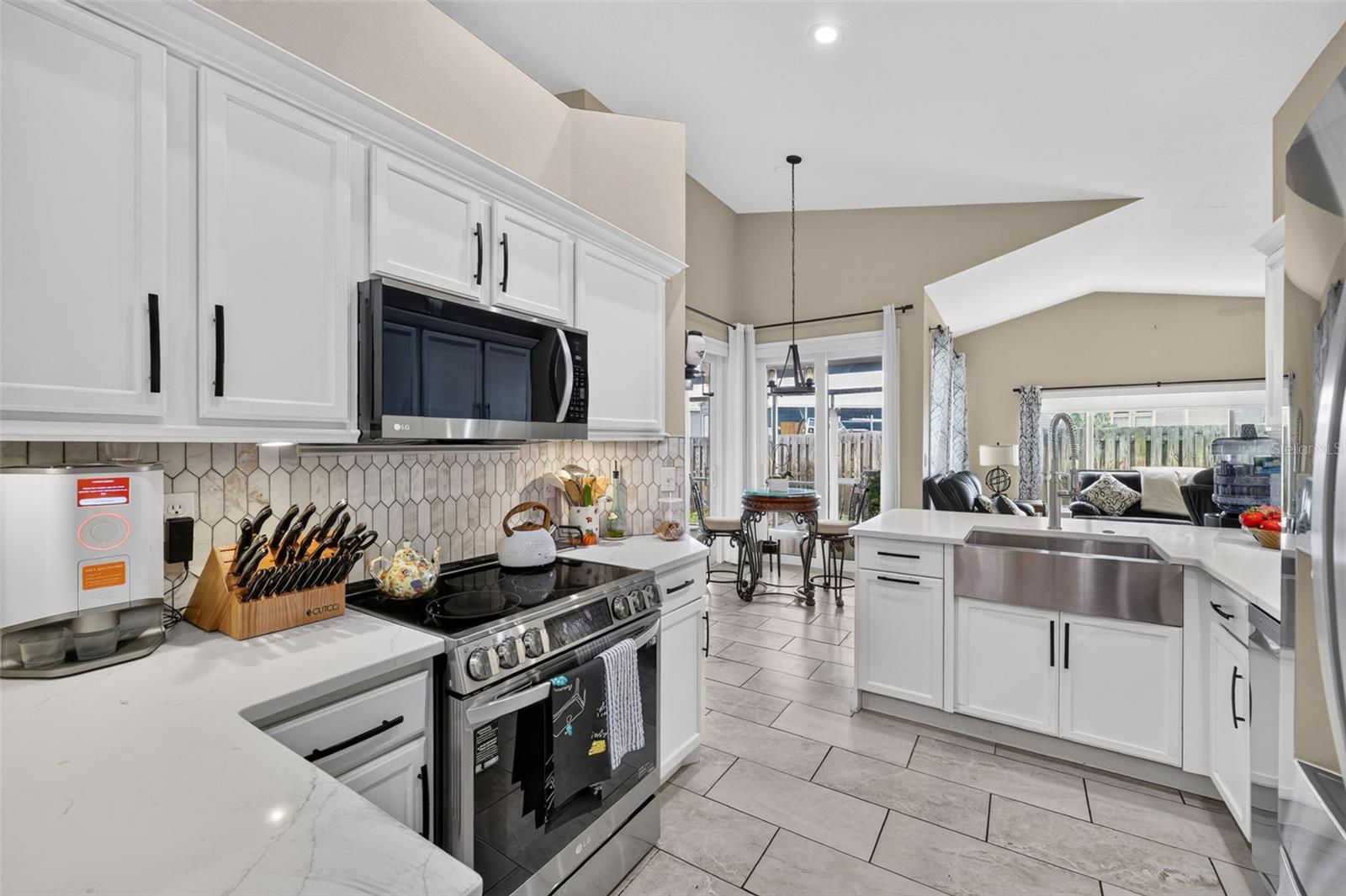 The kitchen is light and bright with stainless appliances, farmhouse sink and soft close cabinetry. This room leads to the dining aream living room and family room