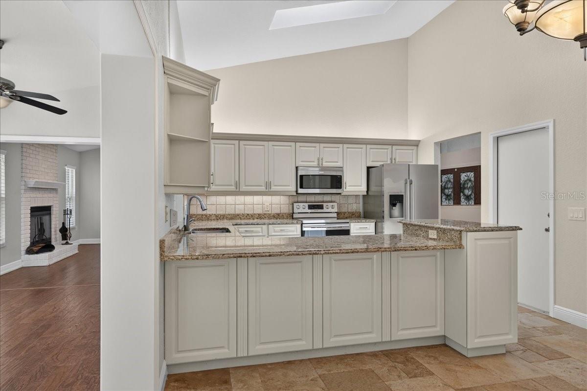 The light and bright eat-in kitchen feels both polished and welcoming, with rich wood cabinetry, granite countertops, stainless steel appliances and generous workspace for everyday meals and entertaining.