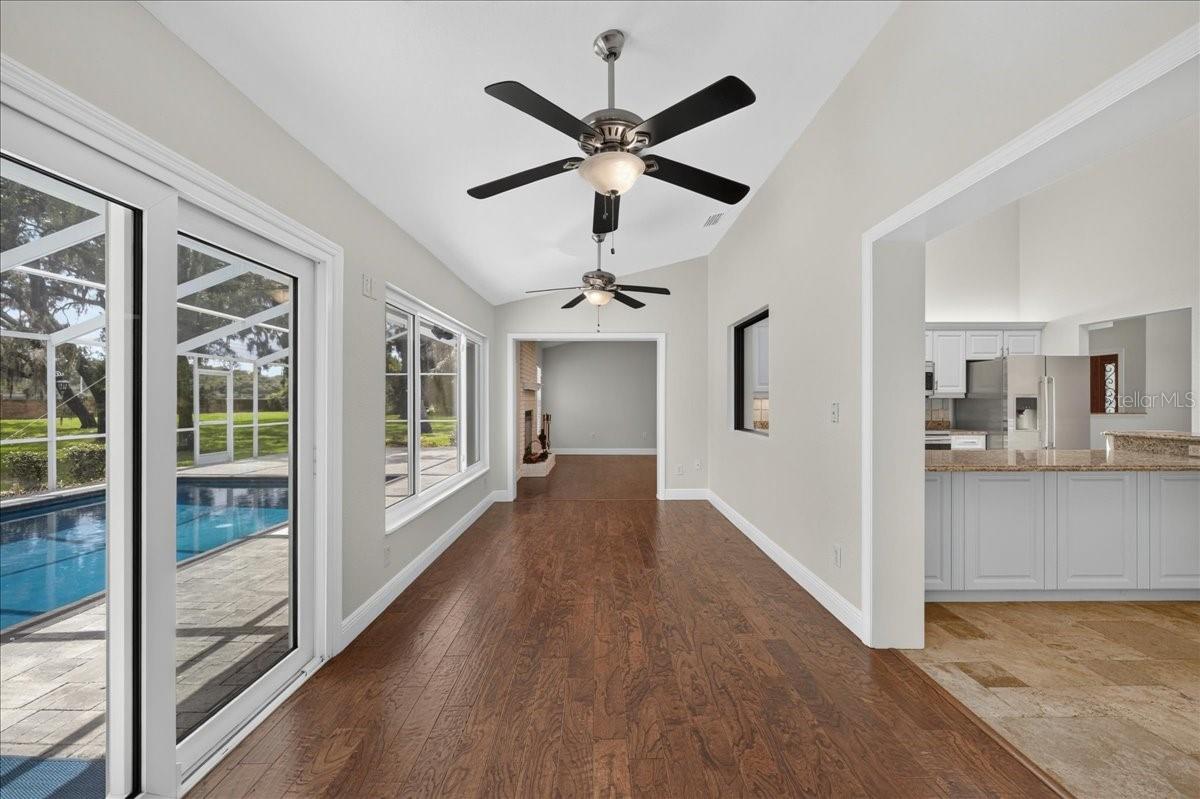 A pass-through connects the kitchen to the spacious Florida room, where walls of windows and impact sliding doors bring in views of the pool and expansive backyard.
