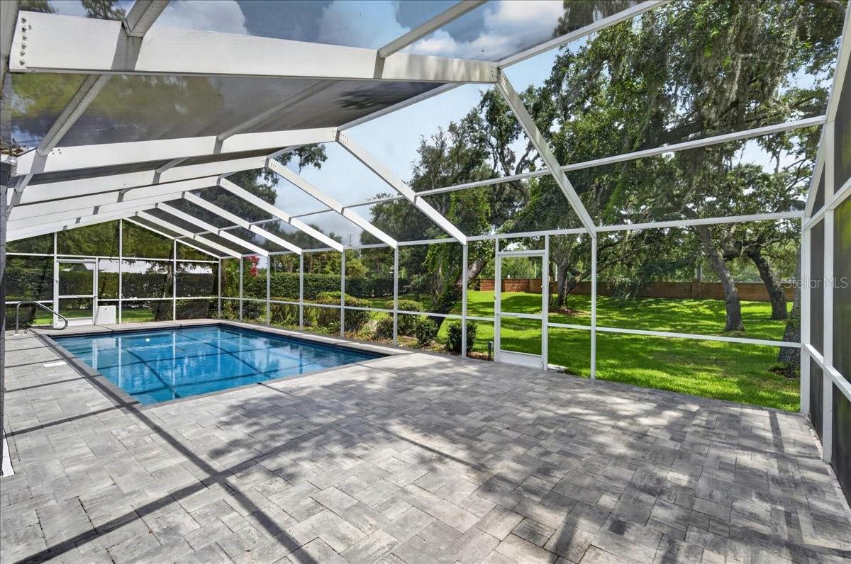 Step out to the screened-in saltwater pool and surrounding travertine patio, where the expansive backyard, lush greenery and mature trees create a natural backdrop for swimming, dining and relaxing.