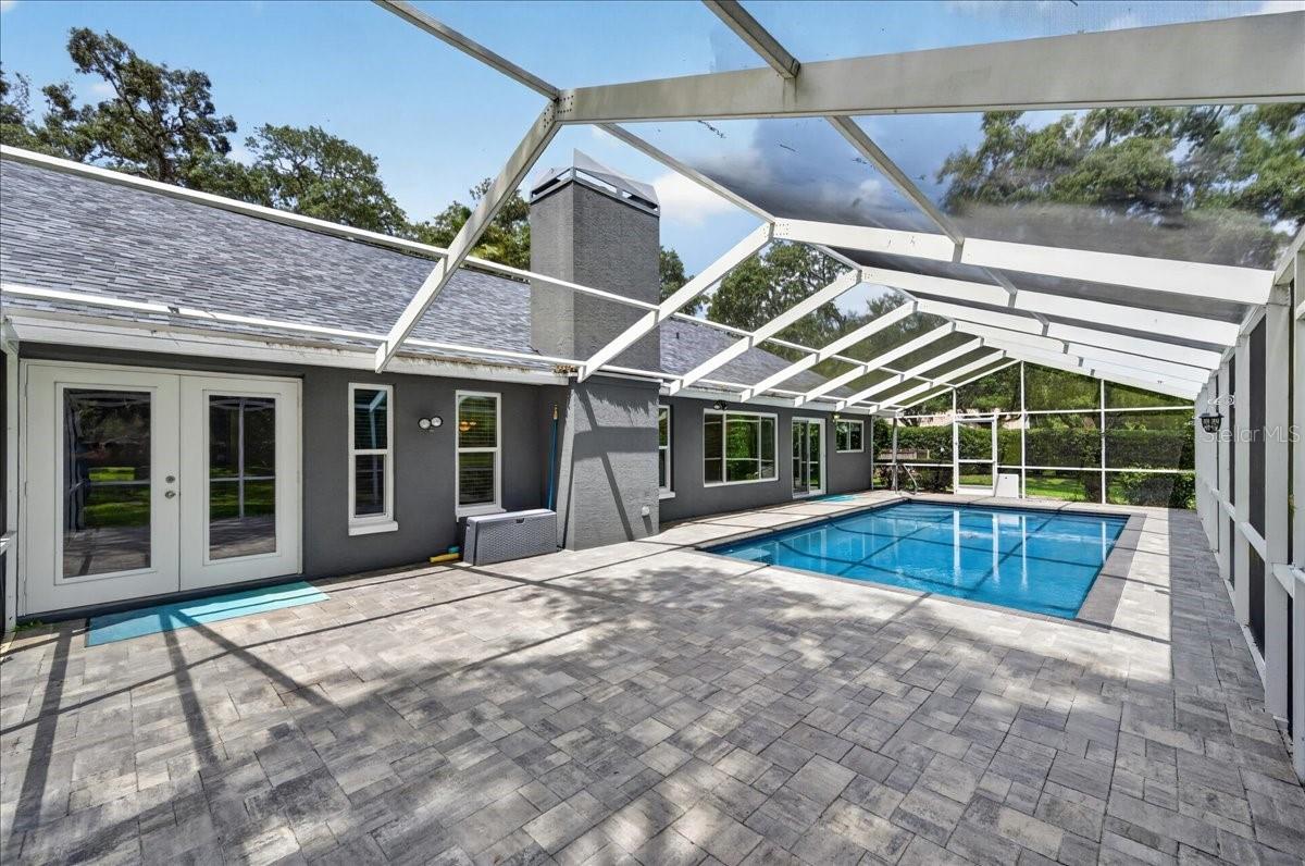 Step out to the screened-in saltwater pool and surrounding travertine patio, where the expansive backyard, lush greenery and mature trees create a natural backdrop for swimming, dining and relaxing.