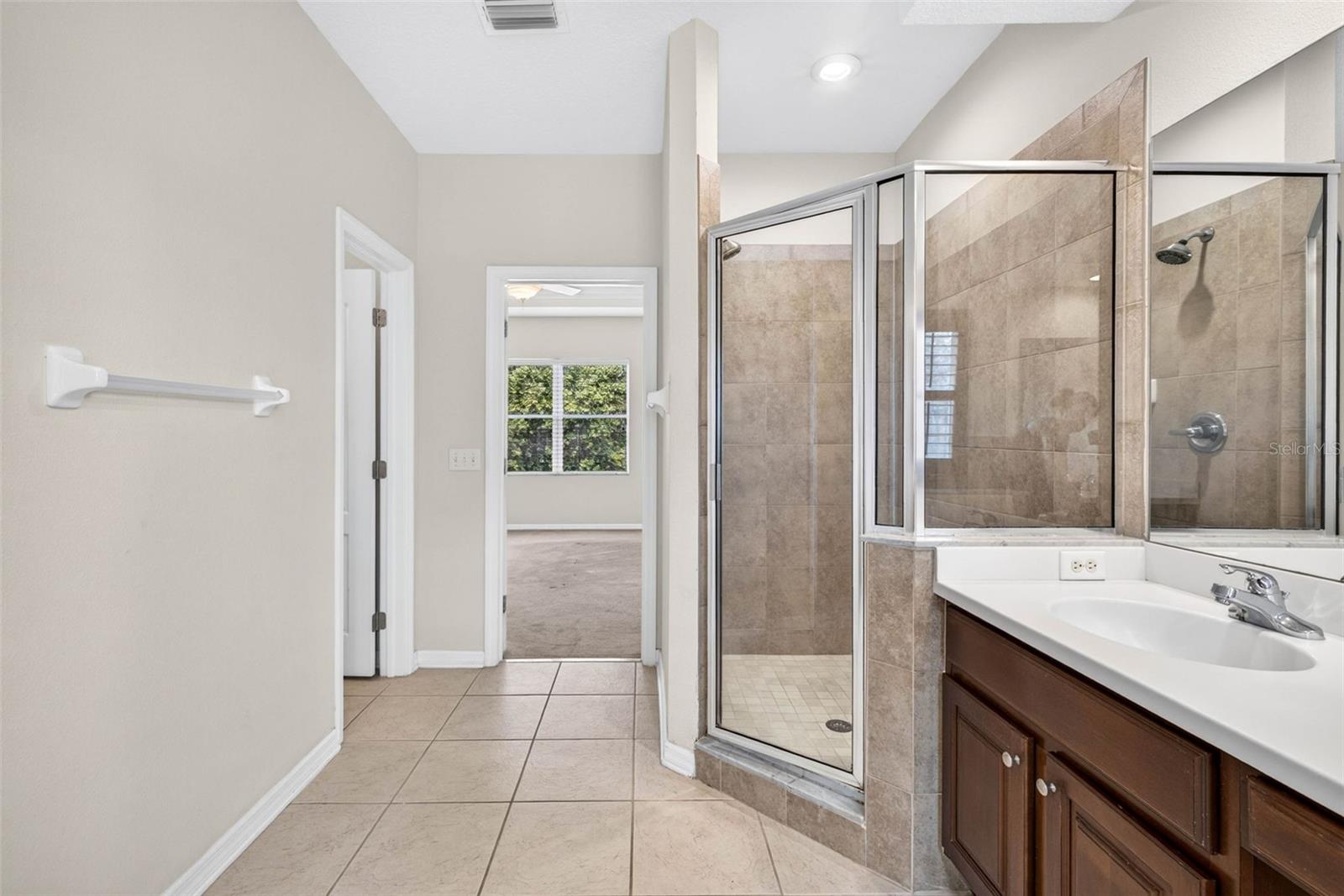 Primary bathroom with walk in shower and split vanities