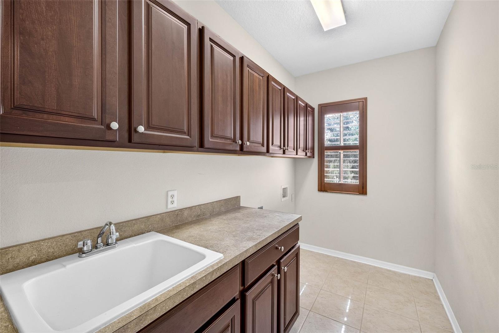 Laundry room with soaking sink and cabinets. Upstairs