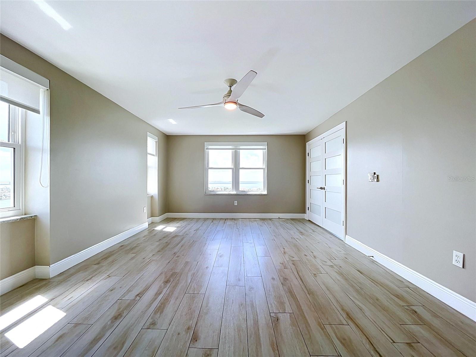 Oversized primary bedroom offers waterfront scenery and views of the Skyway Bridge in the distance.