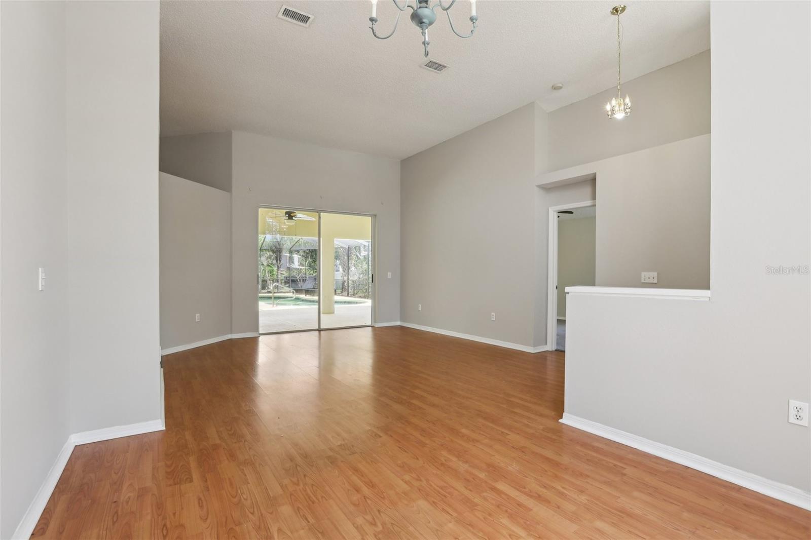 Large Living room overlooks the lanai and pool area