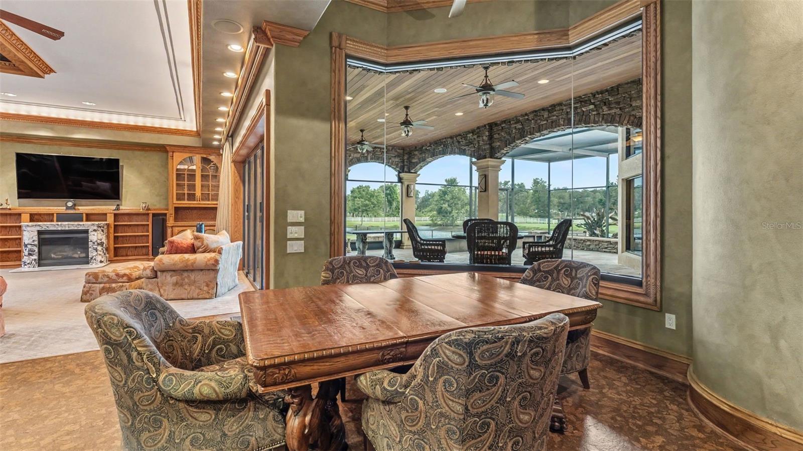 Eat In dining situated at this Frameless glass window  overlooking the Covered Lanai & Pond views.  Antique furniture conveys.