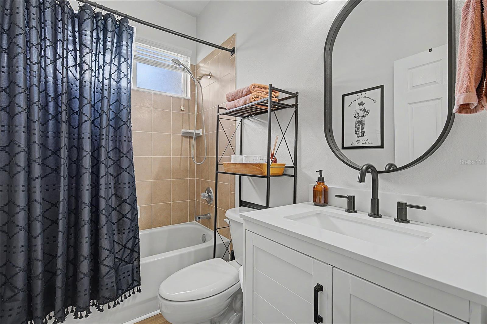 Hall bathroom with updated vanity, lighting, faucet and mirror