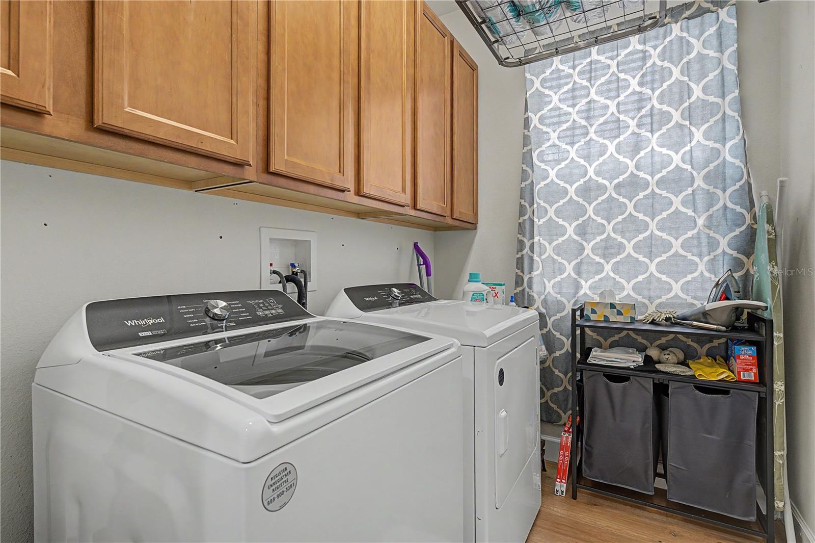 Washer and dryer convey with wooden storage cabinets above