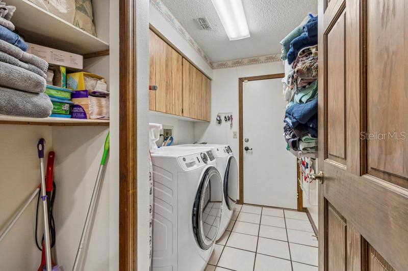 Storage closet in laundry room with utility sink