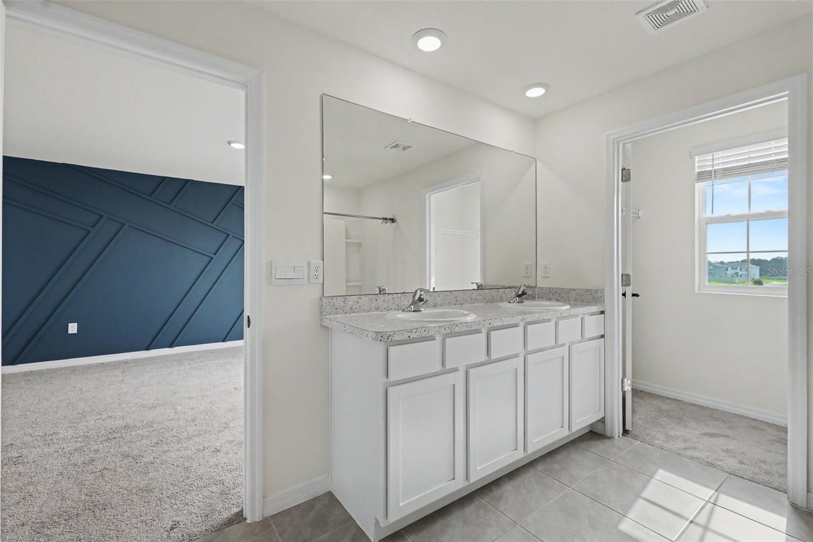 Primary en-suite bathroom with a secondary walk-in closet