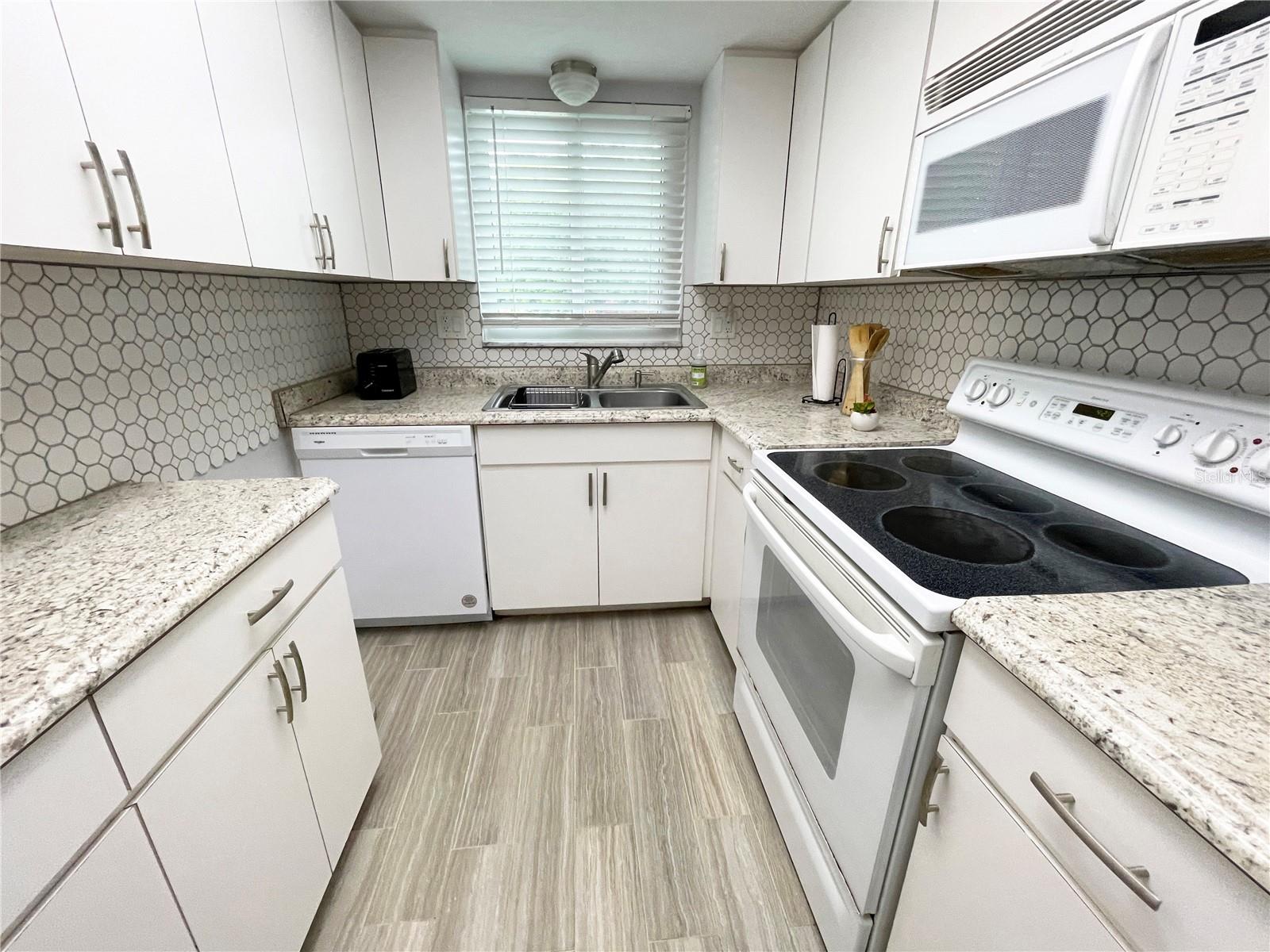 Updated kitchen with dishwasher, microwave, refrigerator and stove.