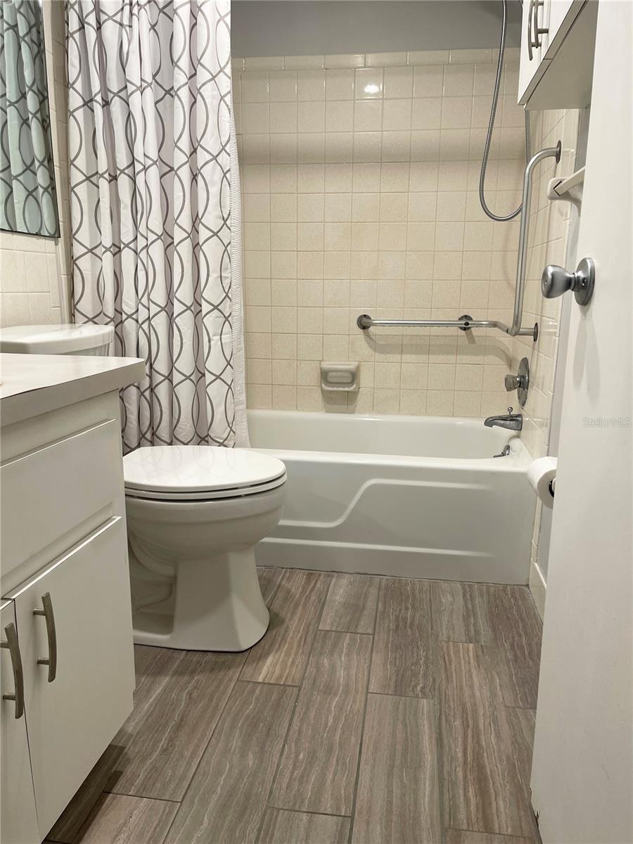 Bathroom with updated flooring and helpful access bars