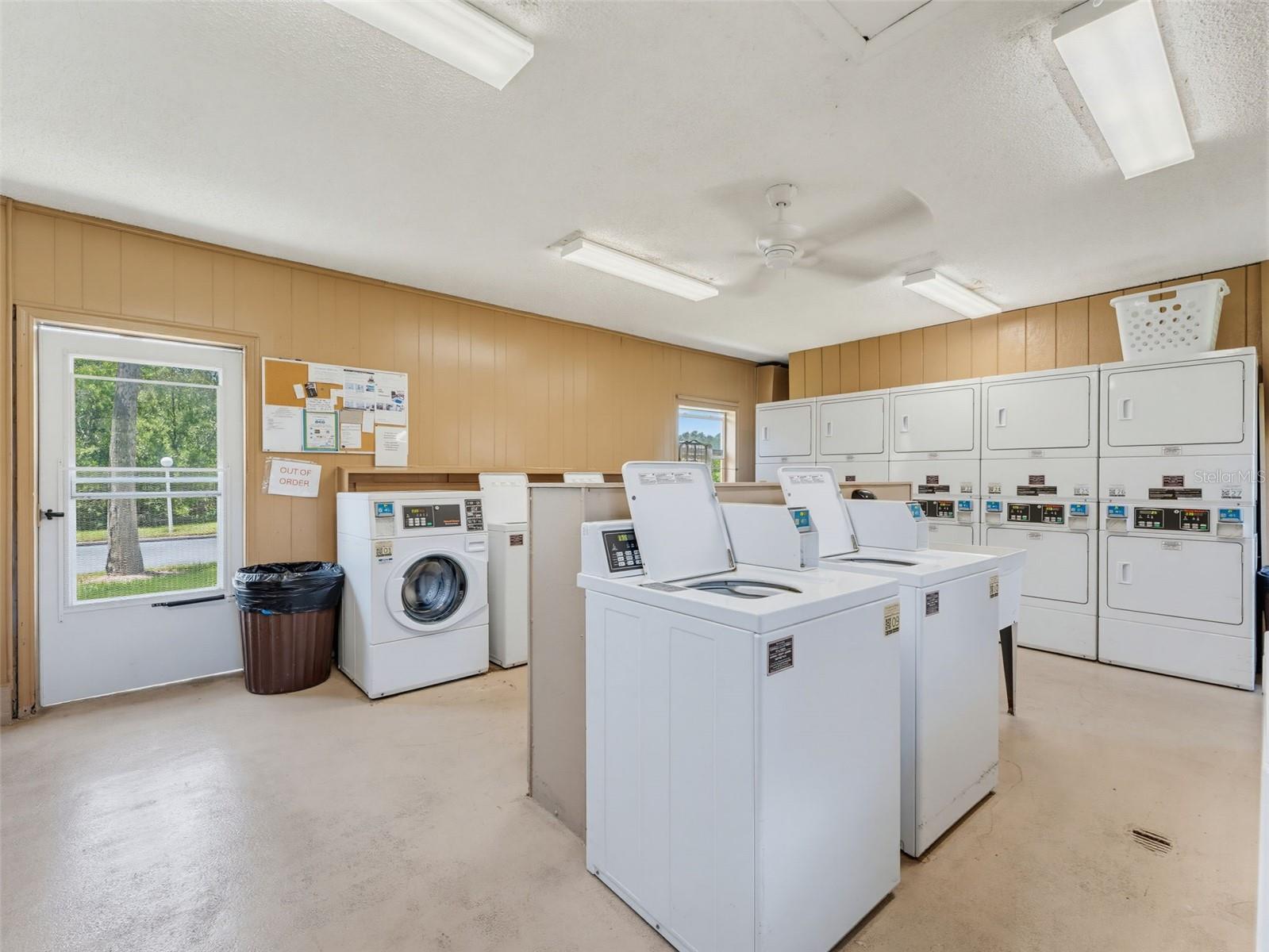 separate laundry room with many washers and dryers.