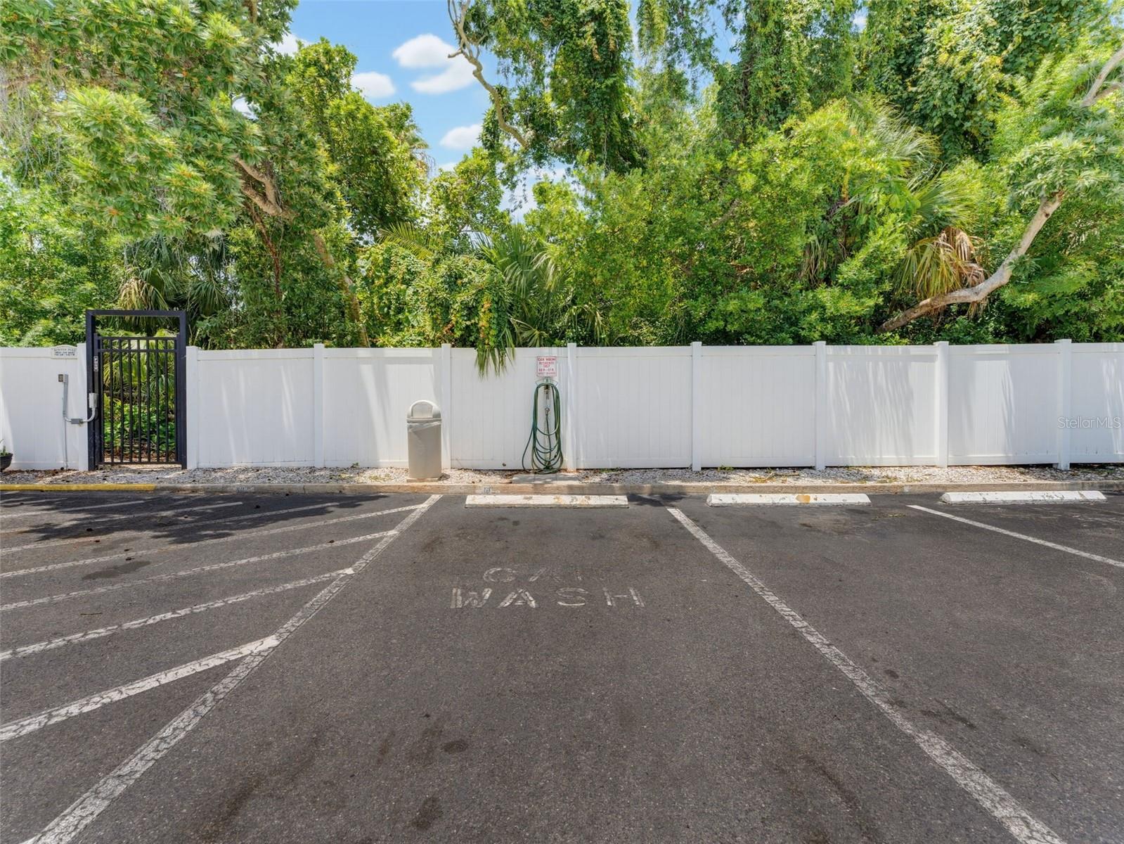 Car wash area with hose, bike rack by shed