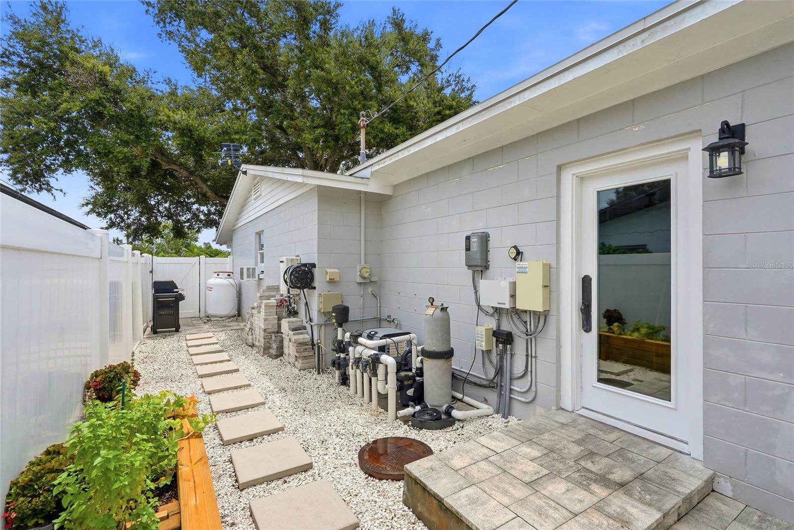 Side yard off the Family Room with Propane tank for heated SPA and a Generator Transfer Switch