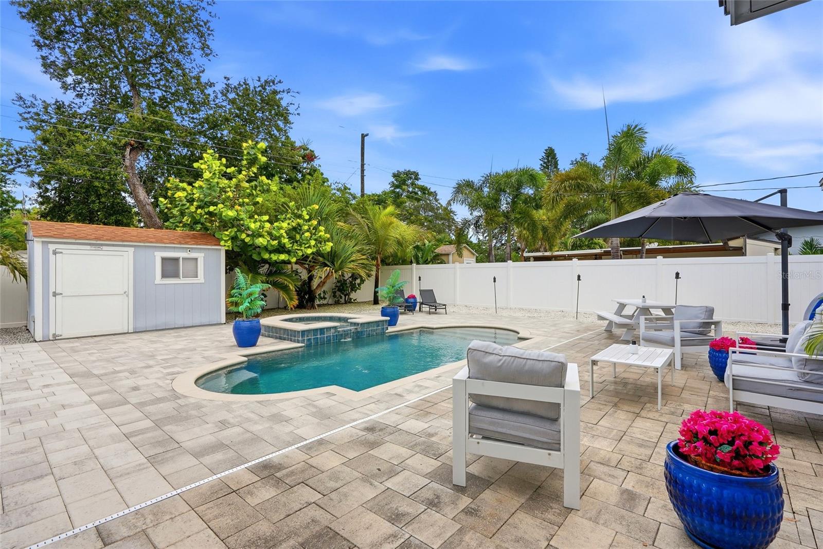 Your very own Maintenance FREE TROPICAL OASIS with a NEW Salt water pool & heated Spill over Spa; 3 Custom built Storage Sheds (2 with electrical); Fire pit; Vinyl privacy fence; and gorgeous brick pavers surrounded by Tropical landscaping