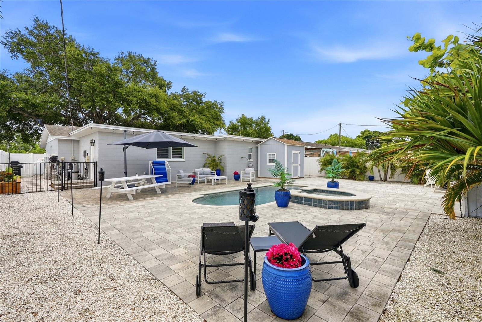 Your very own Maintenance FREE TROPICAL OASIS with a NEW Salt water pool & heated Spill over Spa; 3 Custom built Storage Sheds (2 with electrical); Fire pit; Vinyl privacy fence; and gorgeous brick pavers surrounded by Tropical landscaping