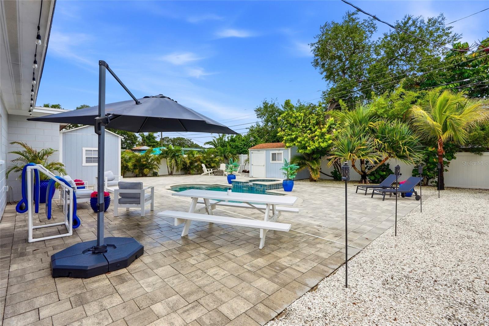 Your very own Maintenance FREE TROPICAL OASIS with a NEW Salt water pool & heated Spill over Spa; 3 Custom built Storage Sheds (2 with electrical); Fire pit; Vinyl privacy fence; and gorgeous brick pavers surrounded by Tropical landscaping