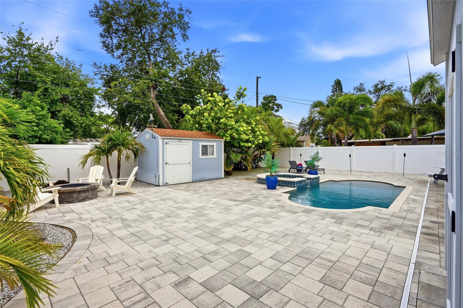 Your very own Maintenance FREE TROPICAL OASIS with a NEW Salt water pool & heated Spill over Spa; 3 Custom built Storage Sheds (2 with electrical); Fire pit; Vinyl privacy fence; and gorgeous brick pavers surrounded by Tropical landscaping