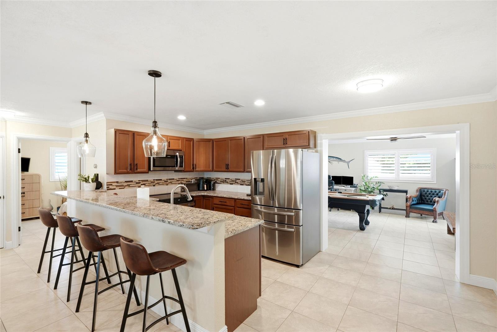 Updated kitchen with Breakfast Bar, Granite counter tops, Stainless Steel appliances, solid wood cabinets, and tile backsplash