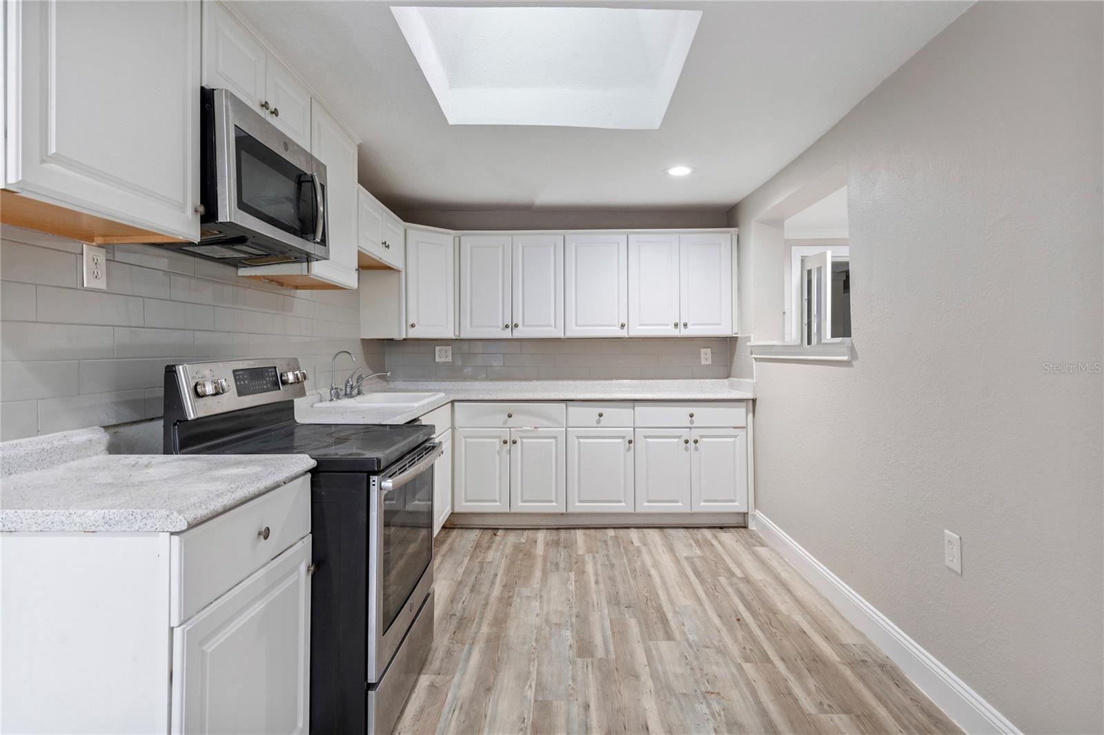 Kitchen has a pass thru window and extra cabinet space.