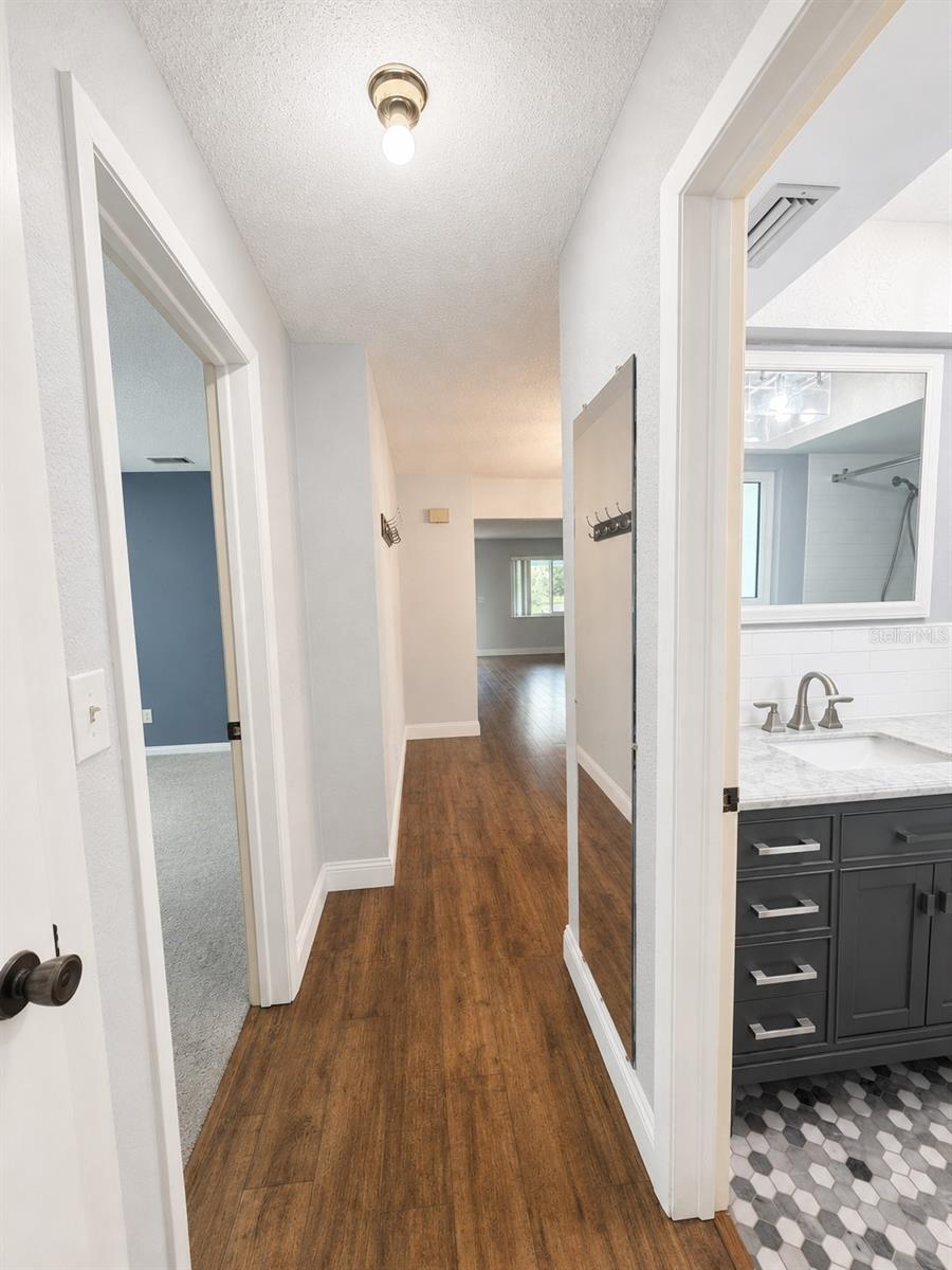 The hallway leads to the second bedroom and steps away to the second full bathroom.