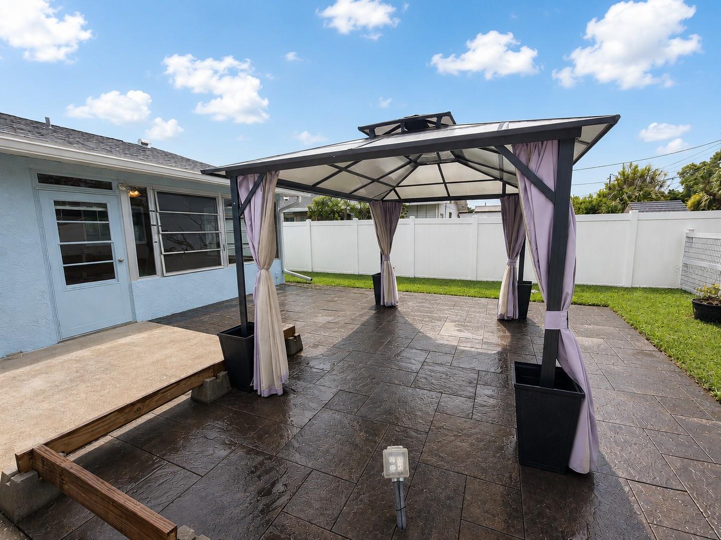 The back yard is fenced.  Step outside into the large backyard!