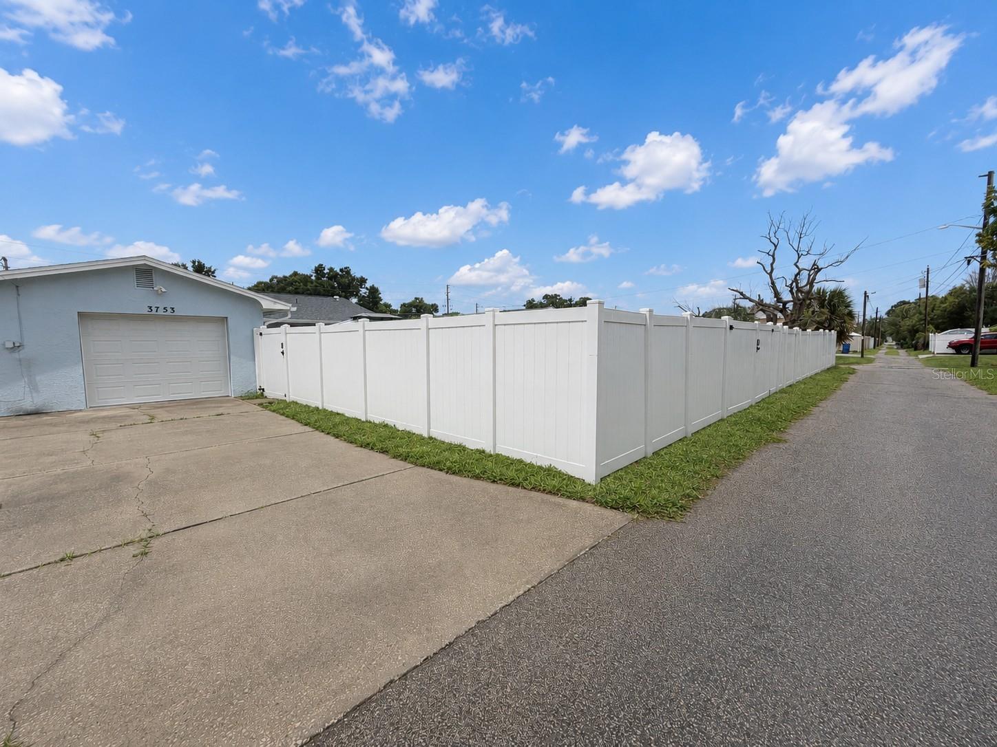 The property features alley access, a large rear driveway & an oversized 1 car garage.