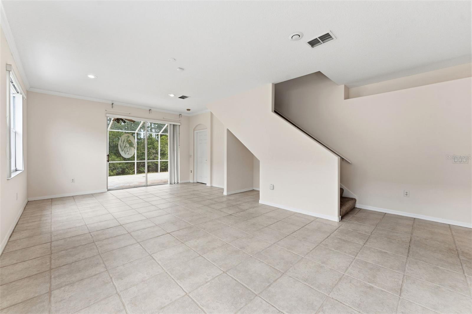 Double sliding doors to the patio and extended screen lanai and stairs to the second floor suite, craft room, or Air-conditioned interior storage!