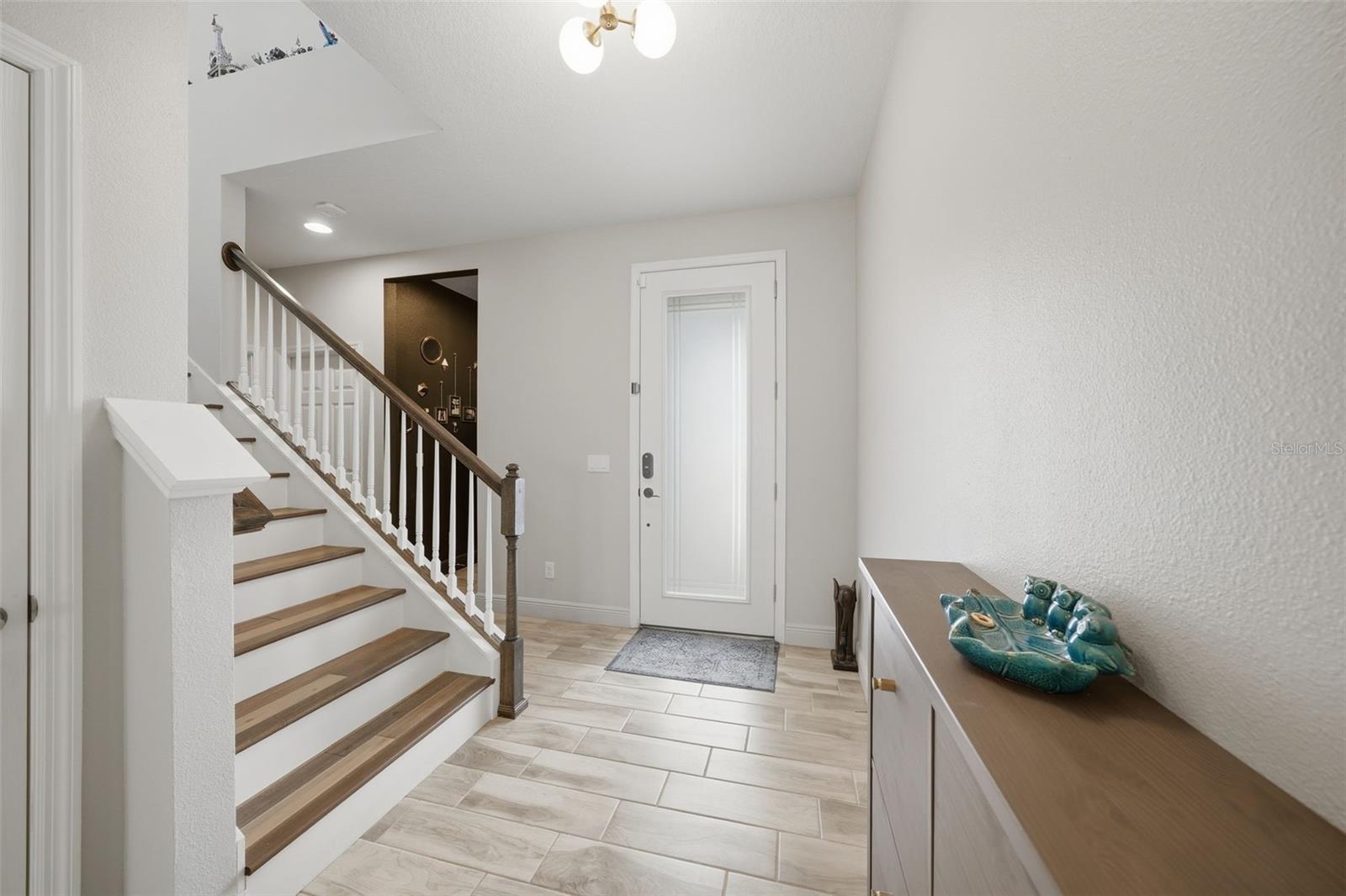 The inviting foyer features a beautiful staircase, adding architectural charm and a dramatic entrance to the home.