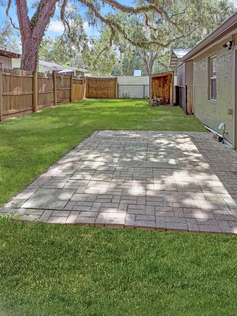 Fenced in backyard with patio