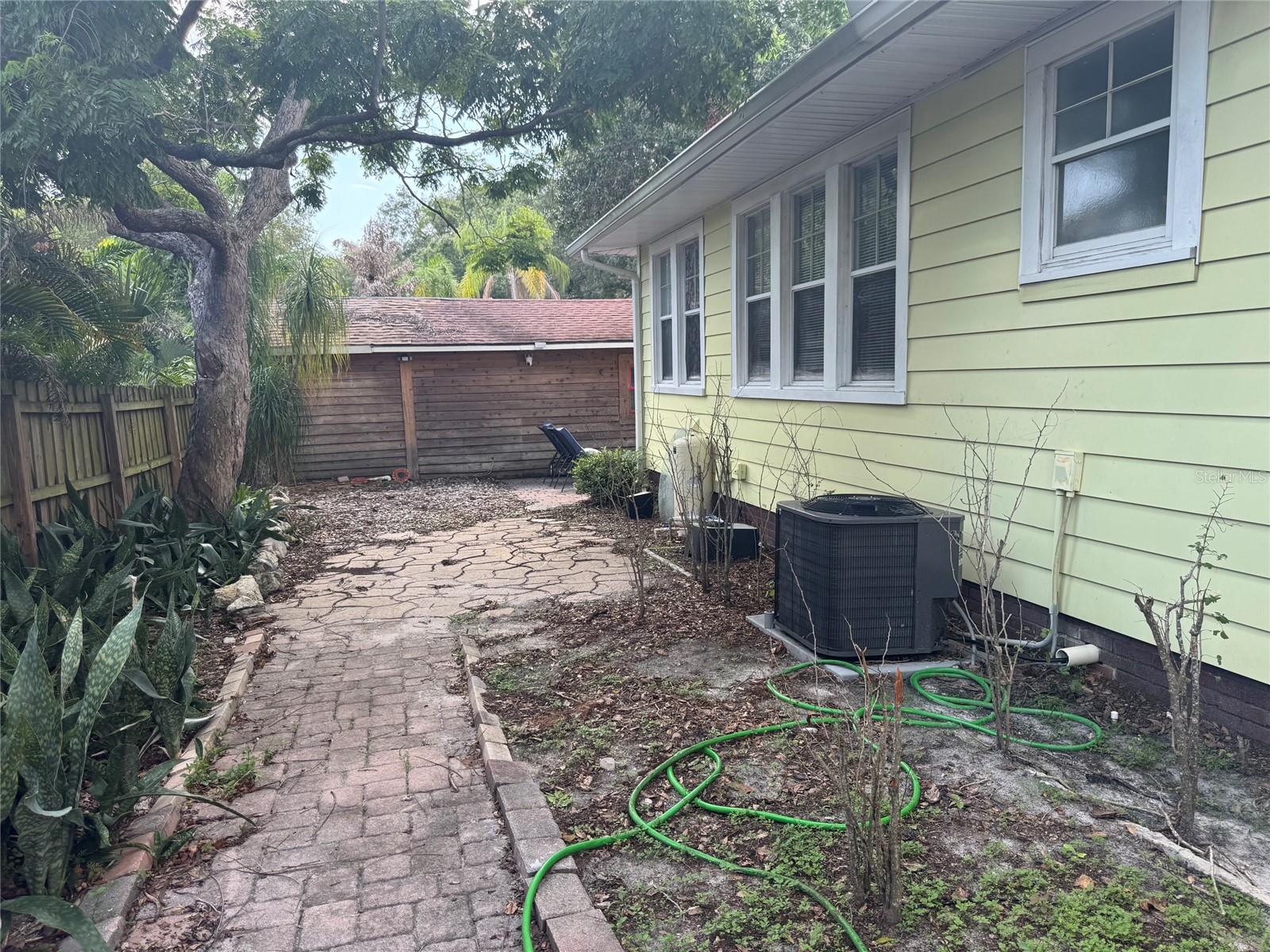 Paved walkway on side of house all throughout the backyard