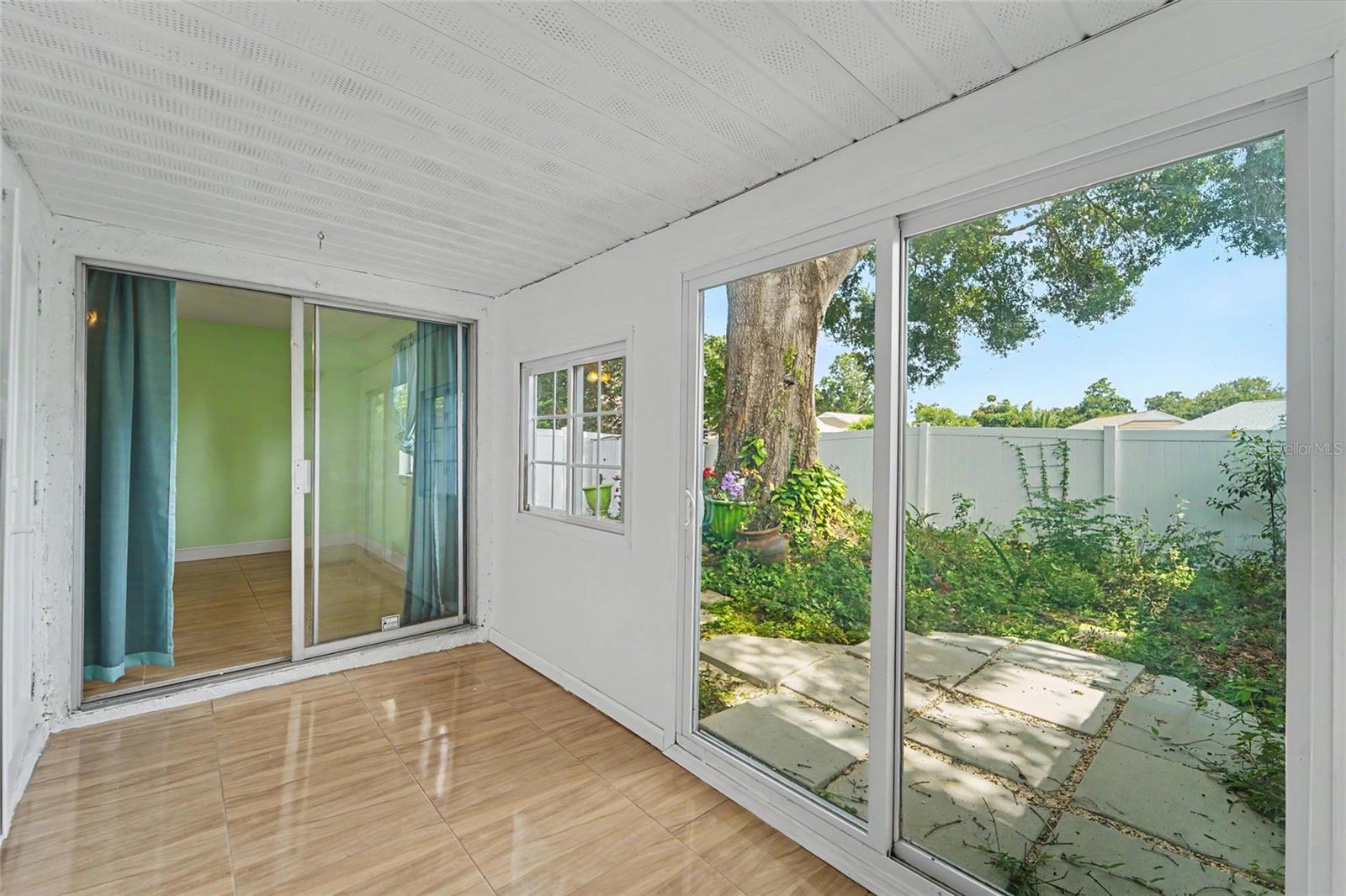 Sunroom with patio view & hurricane impact slider
