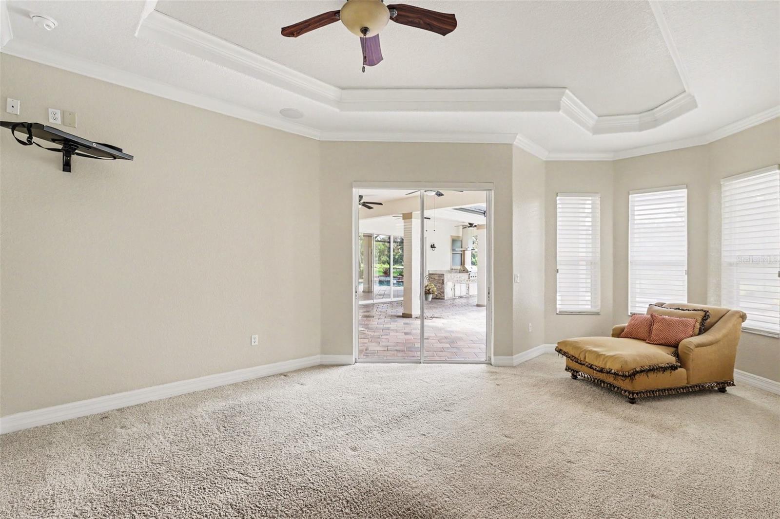 Primary bedroom sliders open to lanai and pool area