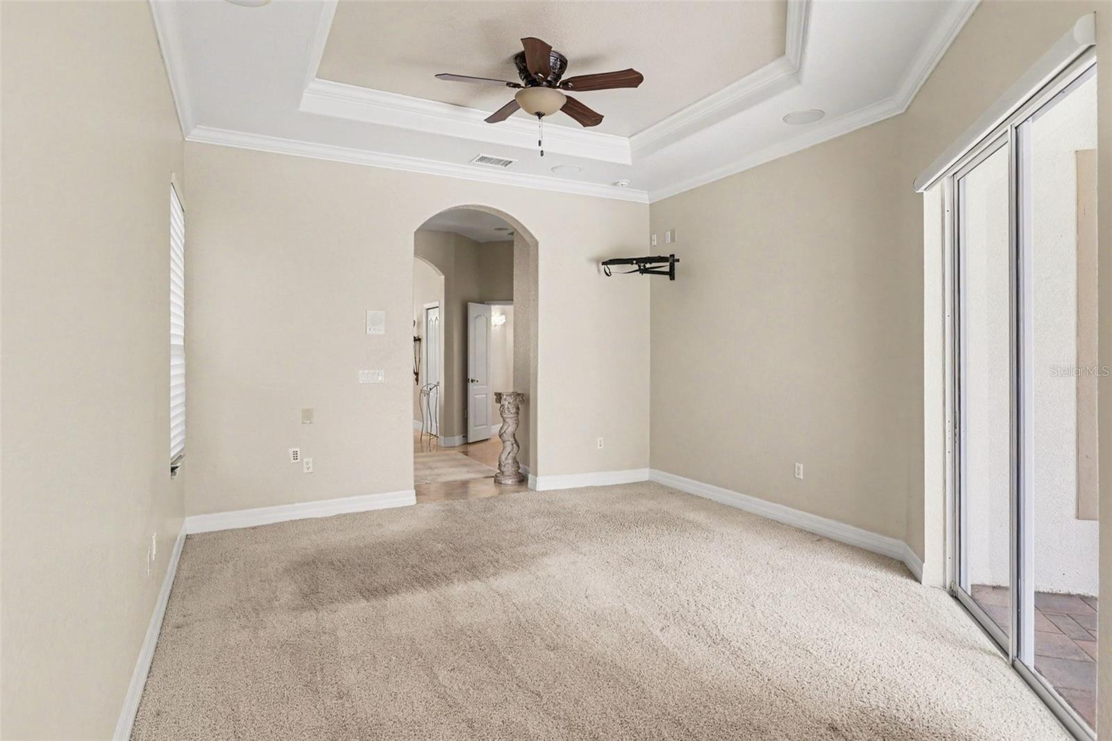 Primary bedroom features tray ceiling with crown molding