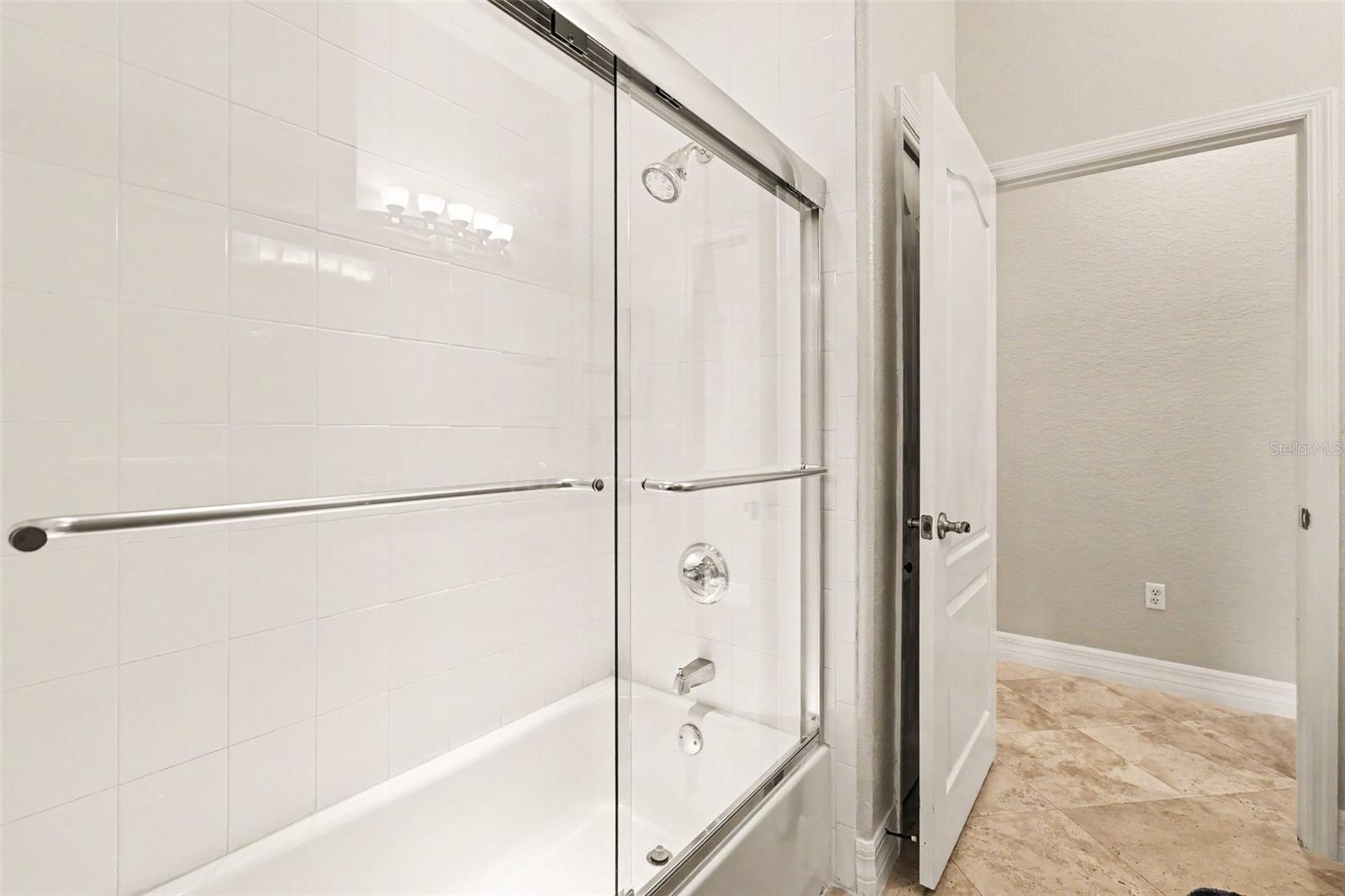 Guest bath has glass tub/shower enclosure