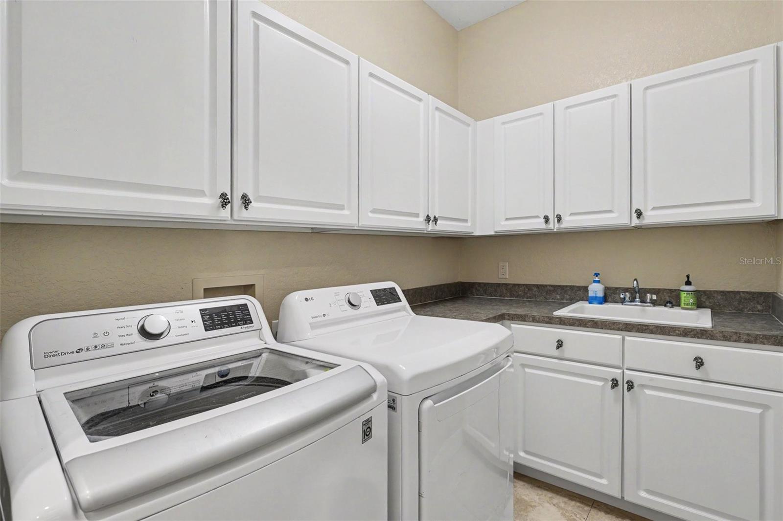 Laundry room has built in cabinets and sink