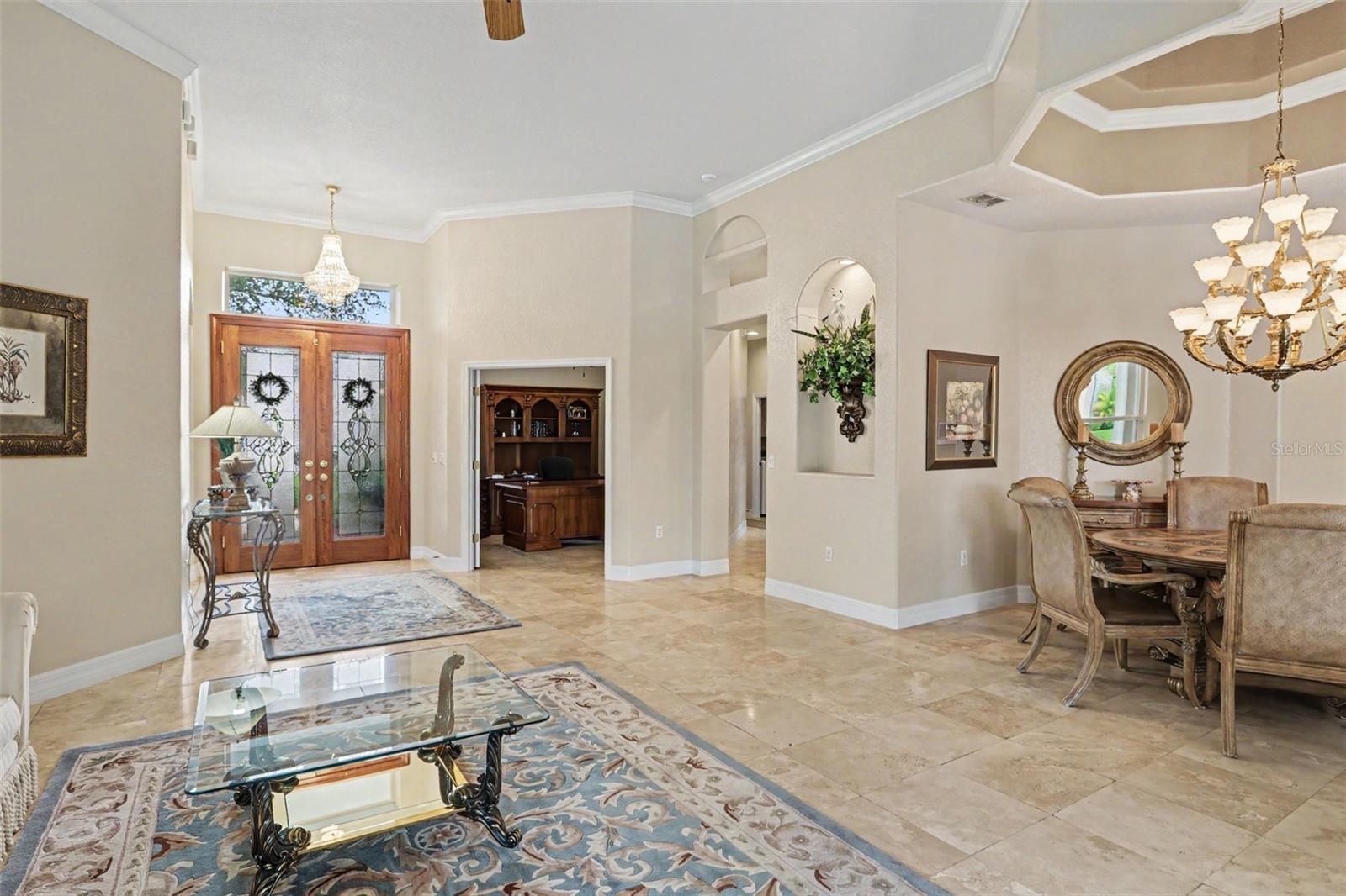 Travertine marble flows from the front door throughout the formal living and dining area