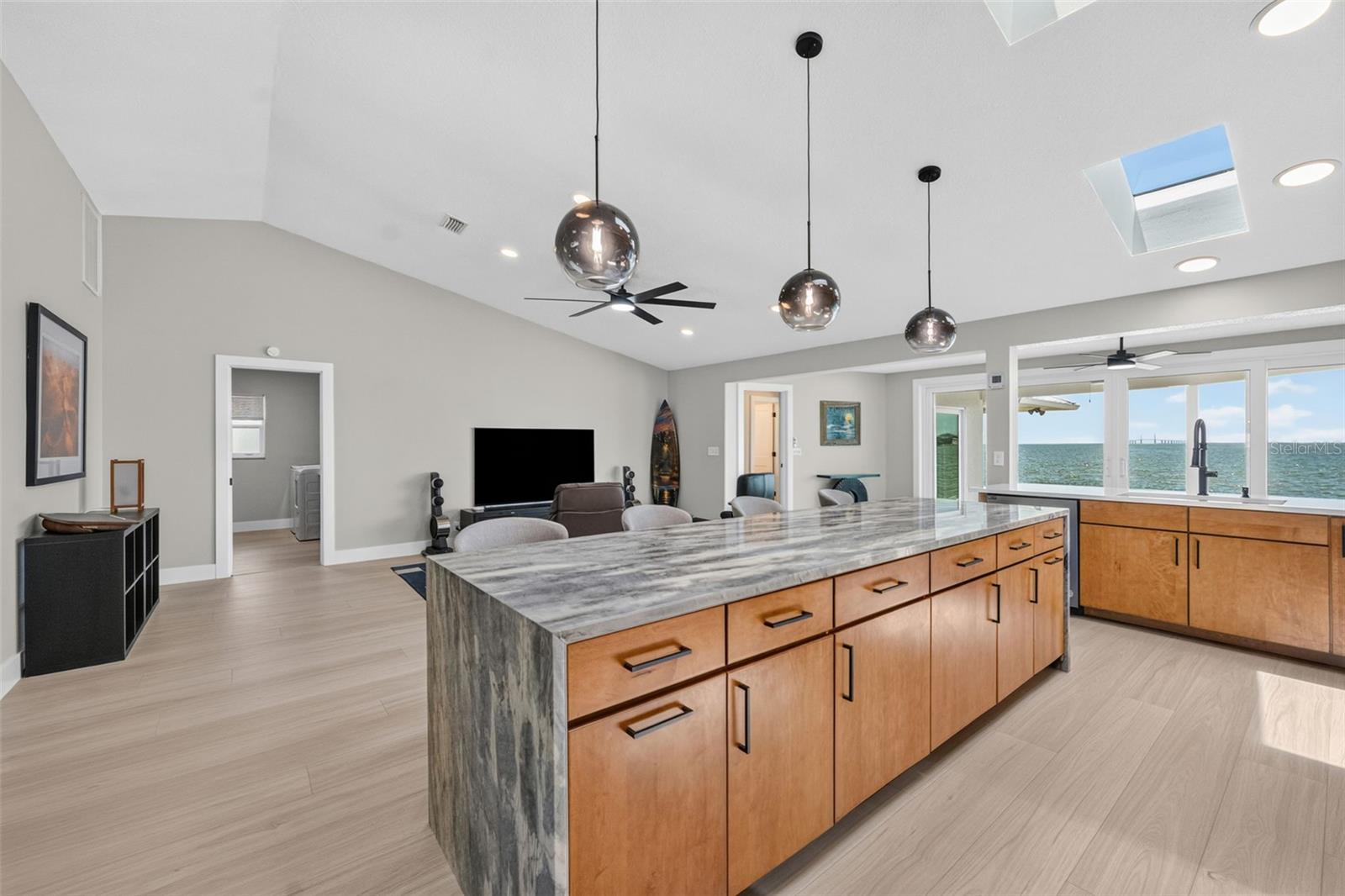 Expansive kitchen island featuring Level 5 granite with a dramatic waterfall edge