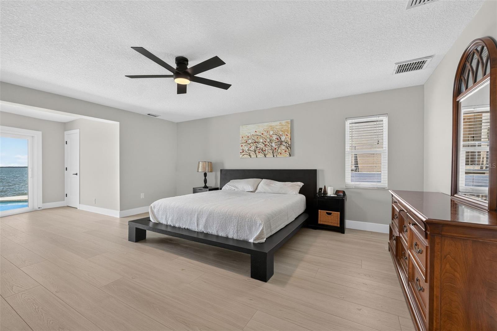 Spacious primary bedroom with new luxury vinyl plank flooring, offering plenty of room for all your furniture and personal touches.