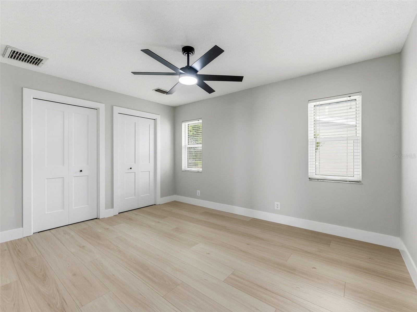 Bedroom 3 with luxury vinyl plank floors and a custom built-in closet, offering plenty of storage and comfort.