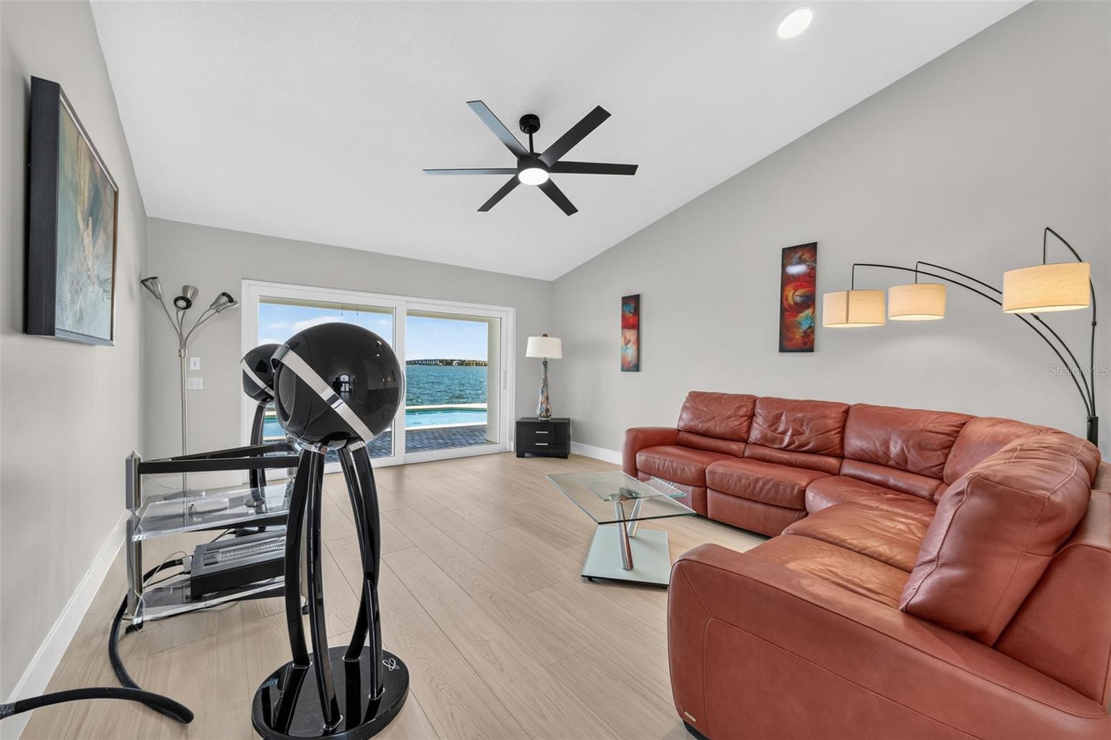 Elegant formal living room featuring sliding glass doors that frame serene water views and fill the space with natural light.