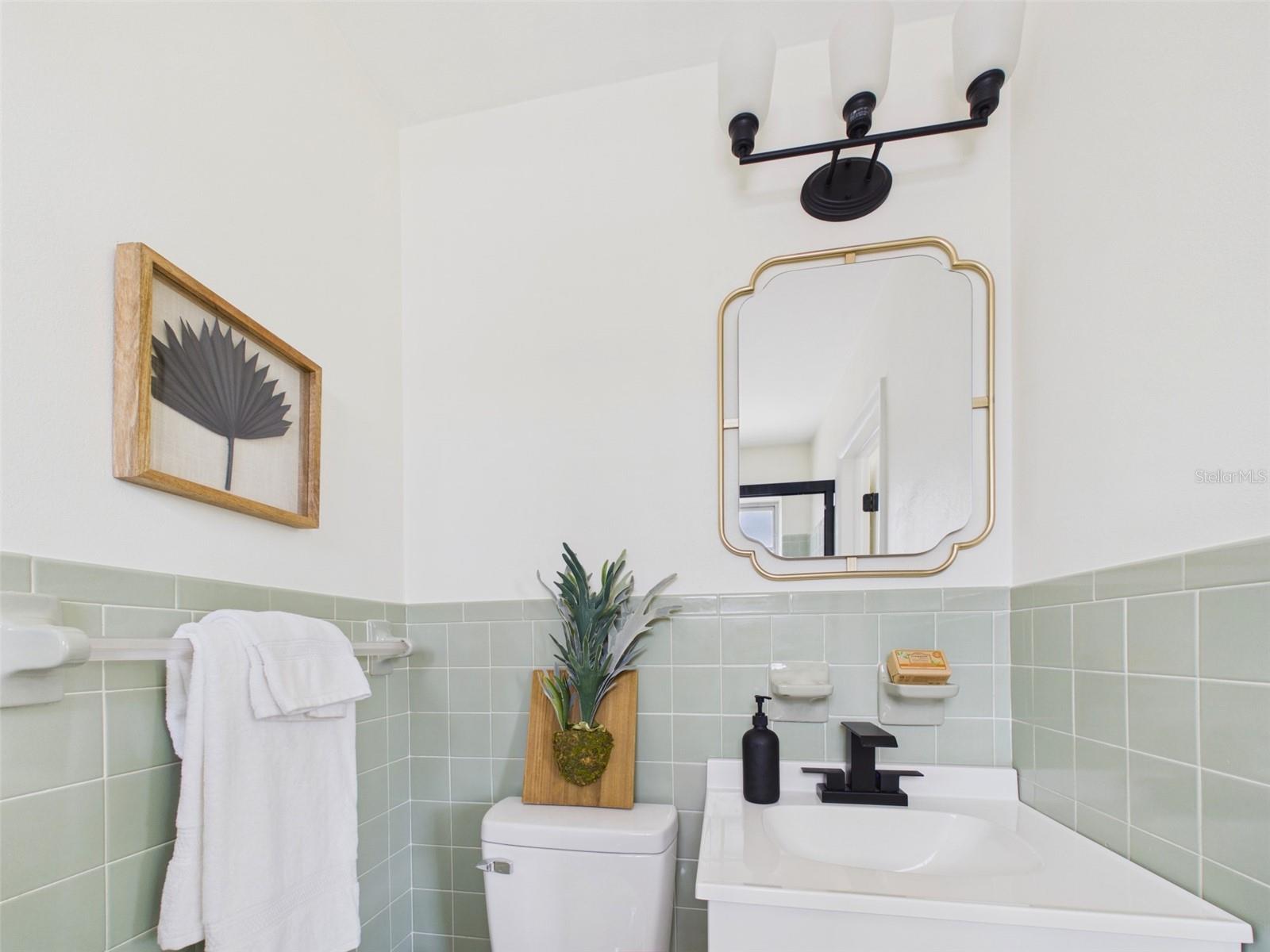Brand new vanity, mirror, lighting fixtures, and toilet