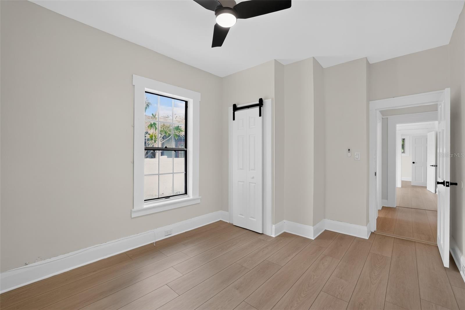 Spacious primary bedroom (approx. 10'4" x 14') with soft natural light and timeless character in this 1922 bungalow