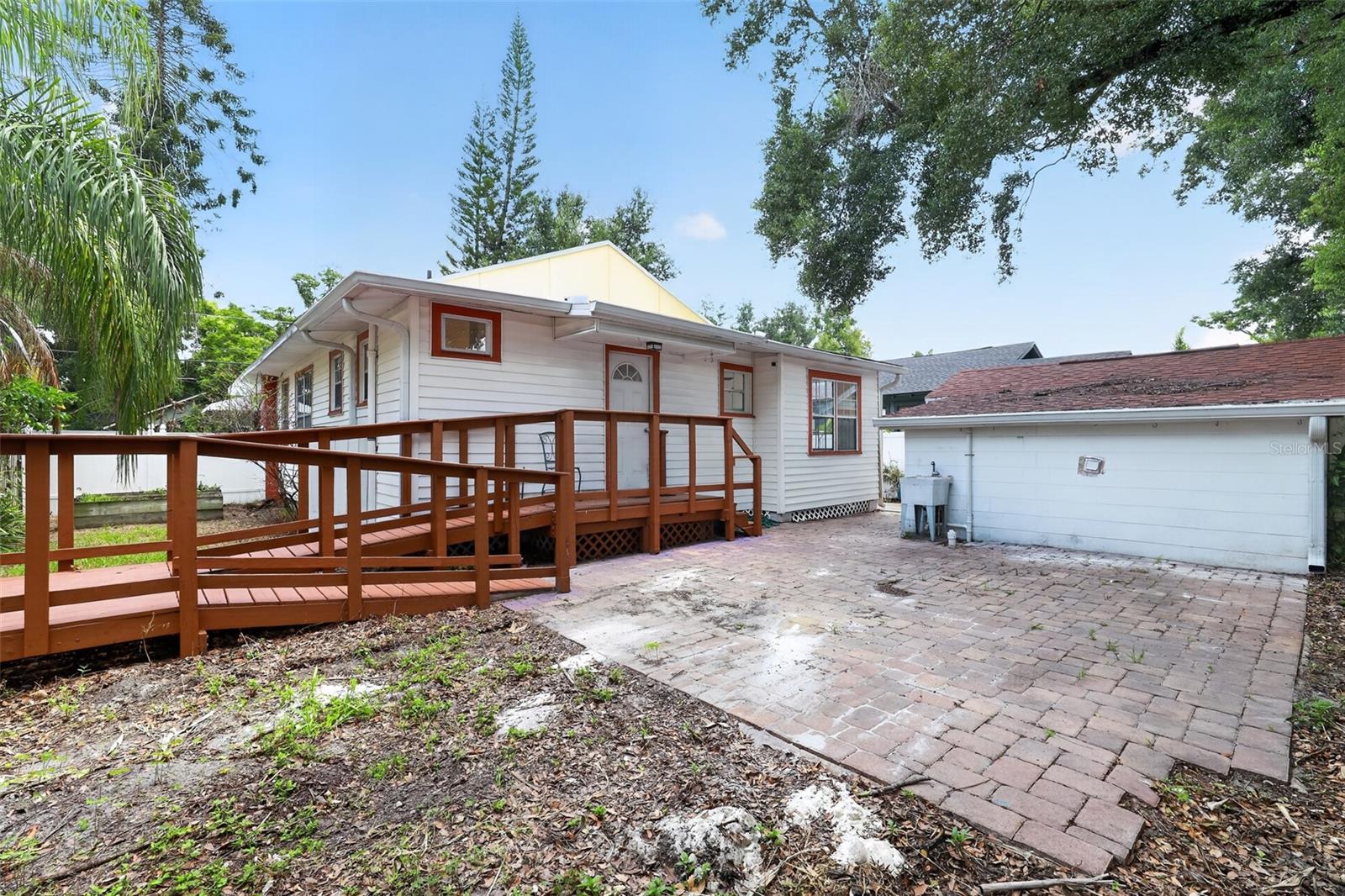 Rear view of this classic 1922 bungalow with paver patio ready for a future fire pit or landscaped oasis