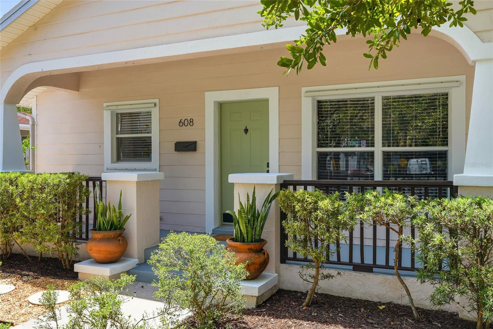 A welcoming front porch with a classic picket-fenced entry sets the tone from the moment you arrive.