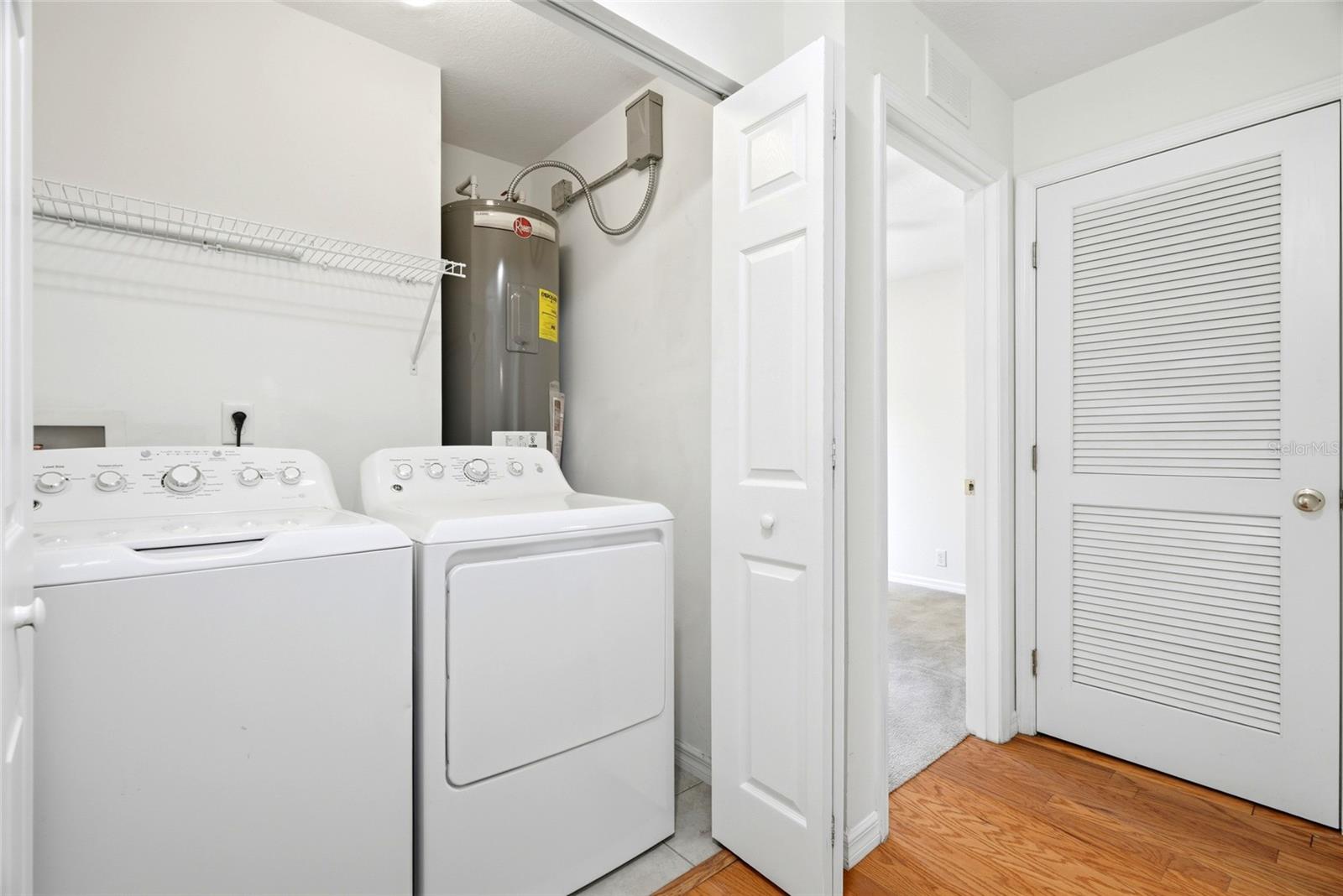 A dedicated laundry closet with side-by-side washer and dryer plus a brand new water heater.