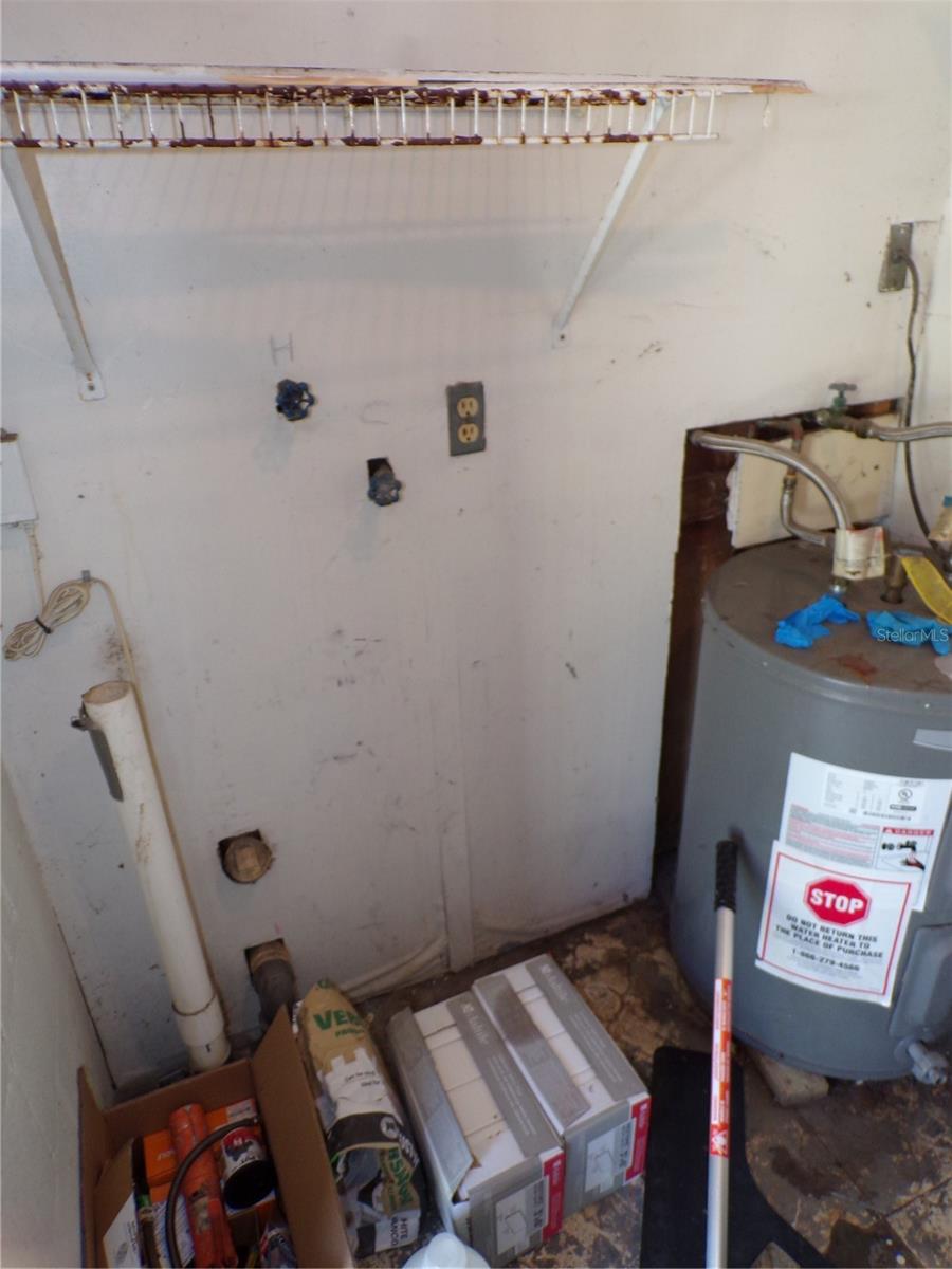 Lockable utility room with laundry hook ups at back of carport