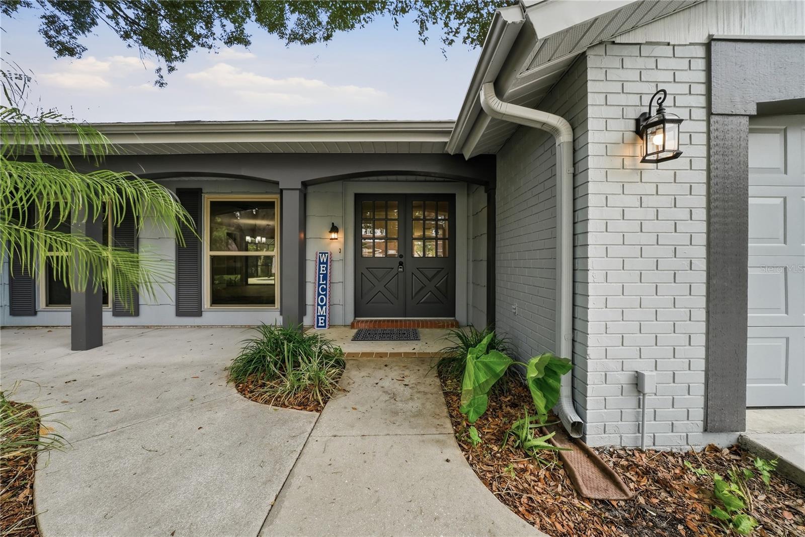 Welcoming covered entrance featuring double front doors and charming architectural details.
